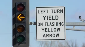 What should you do when you see a flashing yellow traffic signal at the next intersection